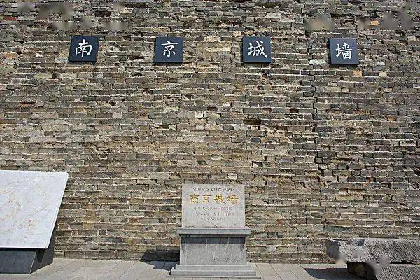 两男子拍打拓印南京古城墙字迹
