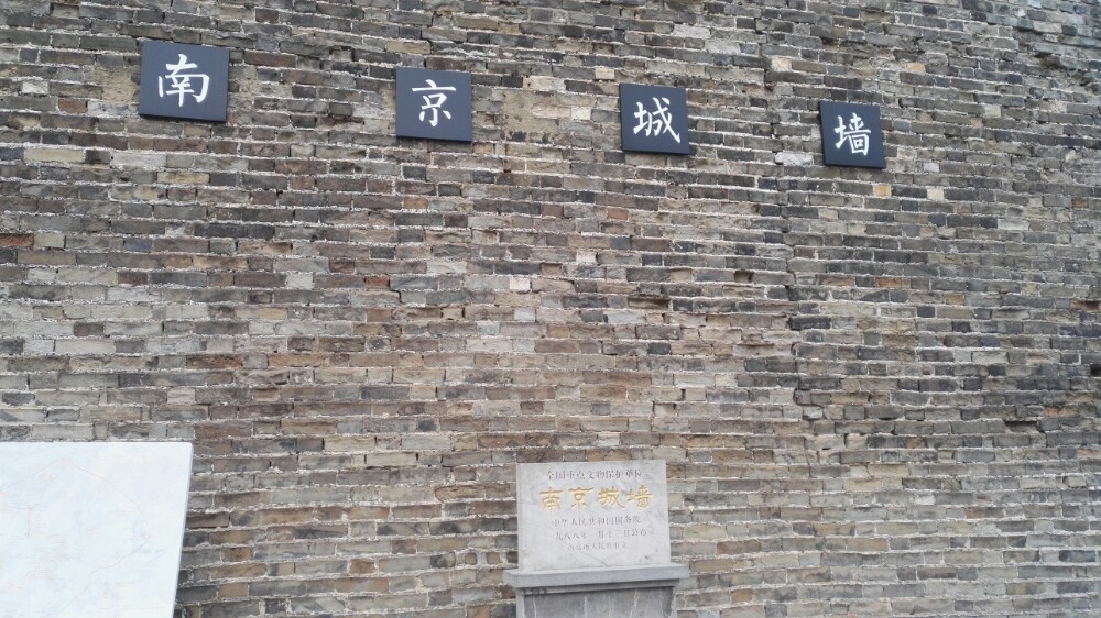 两男子拍打拓印南京古城墙字迹